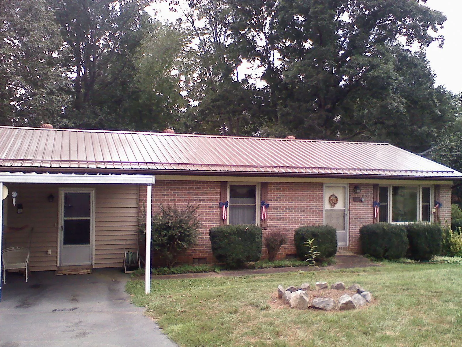 Bronze metal roof and carport on a brick ranch home — Roof Repair work by our crew in Prairie City