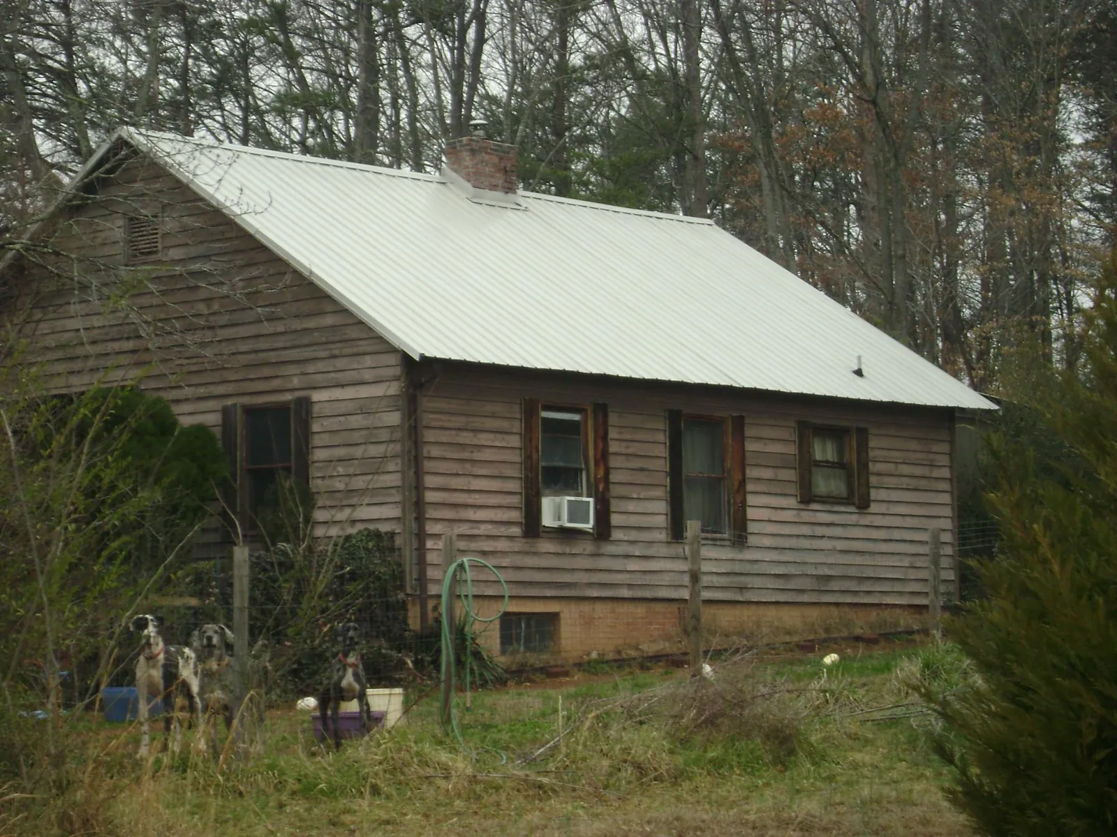 White metal roof on an old wood sided farmhouse, from a Metal Roof Installation job in Prairie City
